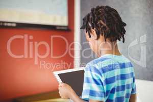 Schoolboy using digital tablet in classroom