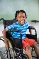 Portrait of cute boy sitting on wheelchair