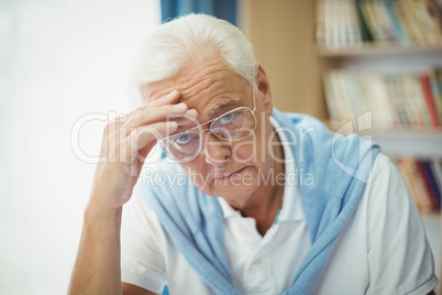 Sad senior man sitting at table