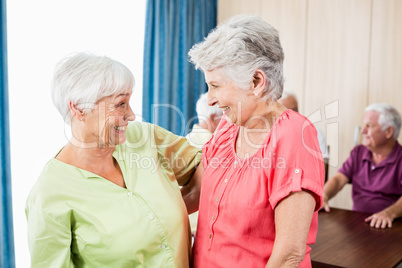 Smiling senior women looking at each other