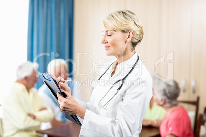 Nurse writing on clipboard