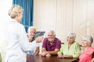 Seniors listening to nurse with tablet