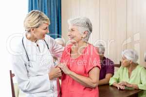 Nurse and senior woman hugging