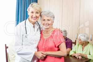 Nurse and senior woman hugging