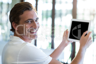 Portrait of happy man using digital tablet