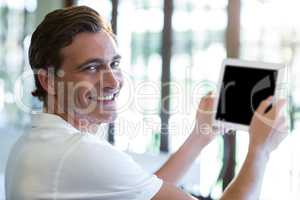 Portrait of happy man using digital tablet