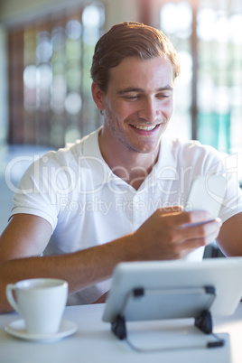 Smiling man using mobile phone