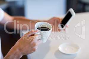 Man having cup of coffee while texting