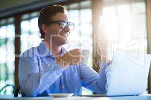Man using mobile phone while having cup of coffee
