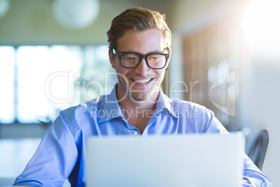 Smiling man using laptop