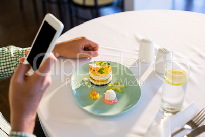 Man using mobile phone while having a lunch