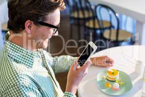 Man using mobile phone while having a lunch