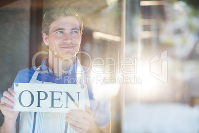 Smiling chef holding open sign