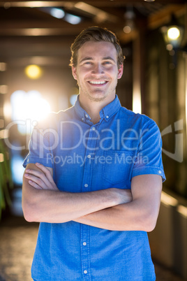Portrait of smiling man standing with arms crossed