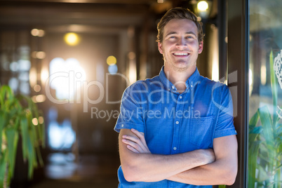 Portrait of smiling man standing with arms crossed