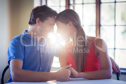 Romantic couple holding hands and sitting face to face