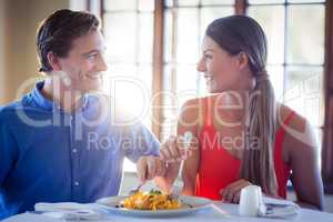 Young couple talking while having lunch