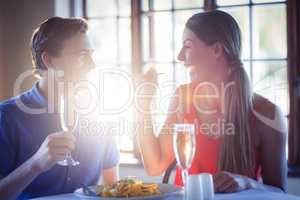 Young woman feeding her man in the restaurant