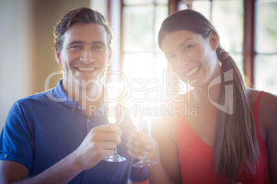 Portrait of young couple toasting champagne flutes while having lunch