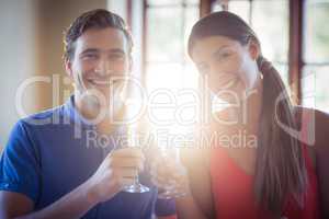 Portrait of young couple toasting champagne flutes while having lunch