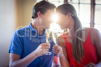 Young couple looking face to face and toasting champagne flutes