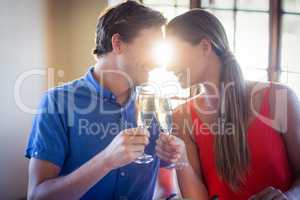 Young couple looking face to face and toasting champagne flutes