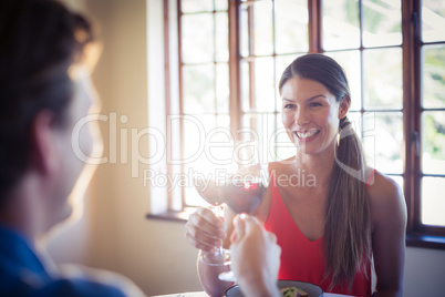 Happy young couple toasting wine glass while having lunch