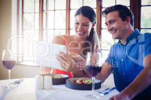 Couple using a digital tablet during lunch