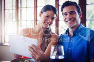 Portrait of happy couple using a digital tablet during lunch