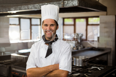 Portrait of smiling chef standing with arms crossed