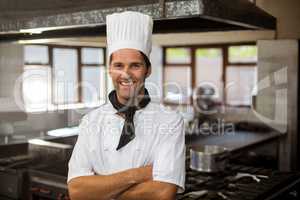 Portrait of smiling chef standing with arms crossed