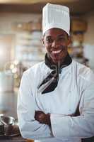 Portrait of smiling chef standing with arms crossed