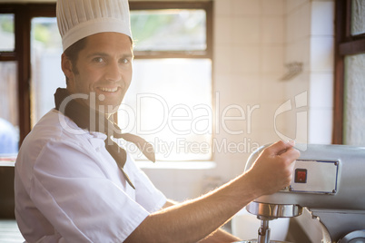 Portrait of chef blending the batter in mixing blender
