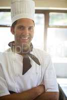 Portrait of smiling chef standing with arms crossed