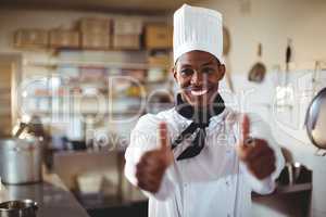 Portrait of smiling chef showing thumbs up