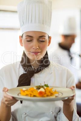 Close-up of head chef with eyes closed smelling food