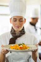 Close-up of head chef with eyes closed smelling food