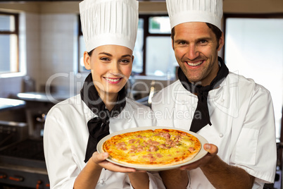 Portrait of two chef presenting a pizza