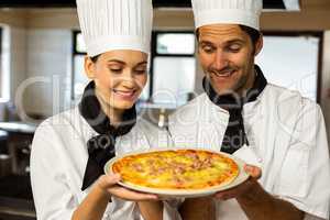 Two head chef presenting a pizza