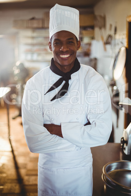 Portrait of smiling chef standing with arms crossed