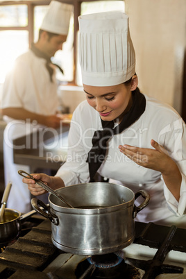 Smiling head chef stirring in cooking pot