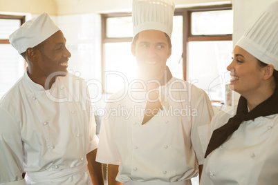 Head chef smiling while having a discussion with colleague