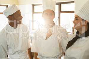 Head chef smiling while having a discussion with colleague