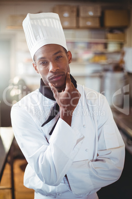 Portrait of thoughtful chef holding his hand on chin