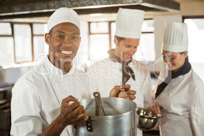 Portrait of smiling chef holding a cooking pot