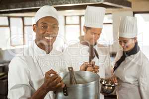 Portrait of smiling chef holding a cooking pot