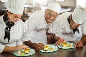 Chefs team finishing dessert plates