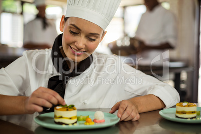 Female chef finishing dessert plates
