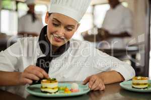 Female chef finishing dessert plates
