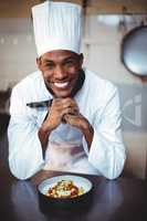 Portrait of smiling head chef presenting salad